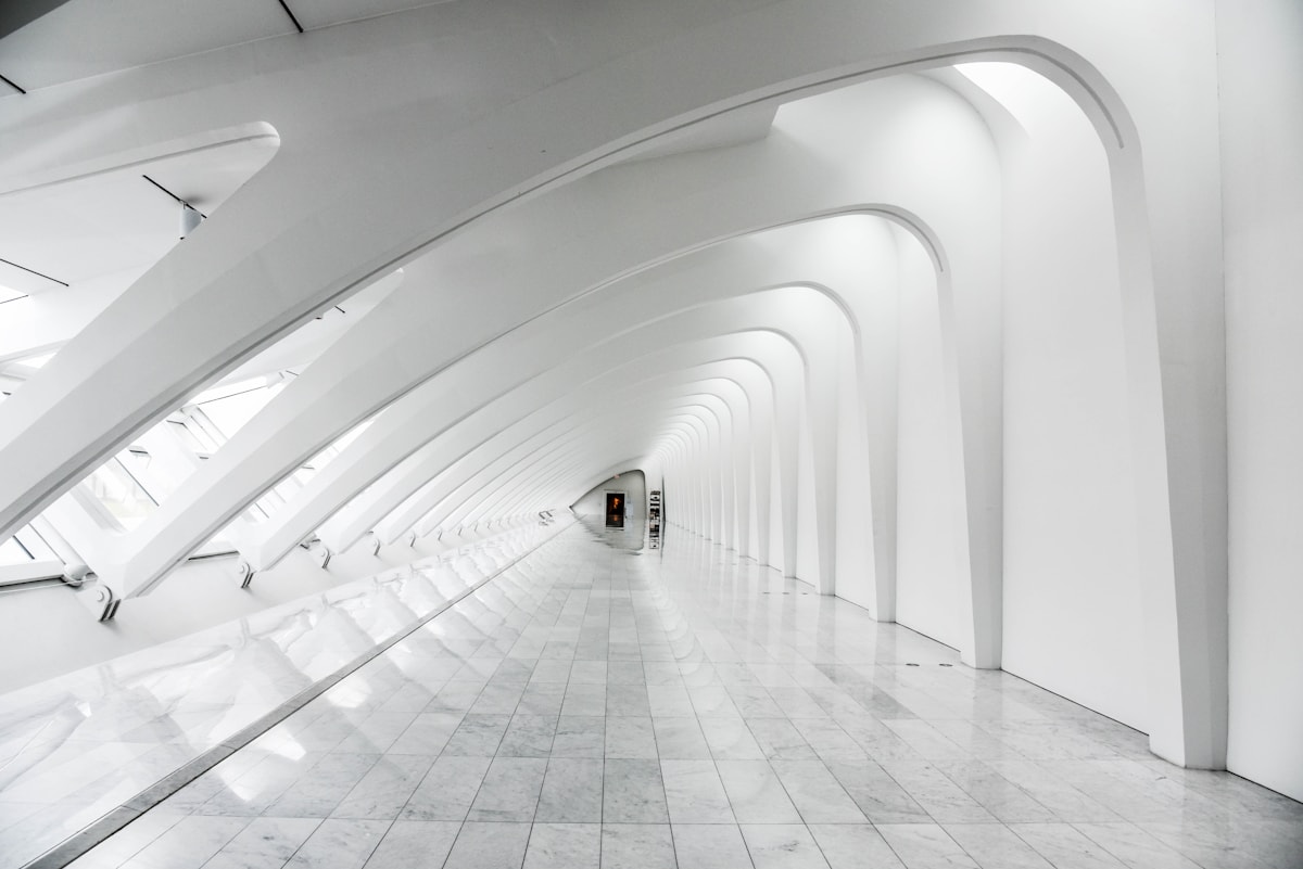 Curved lit interior corridor used as a contact page backdrop